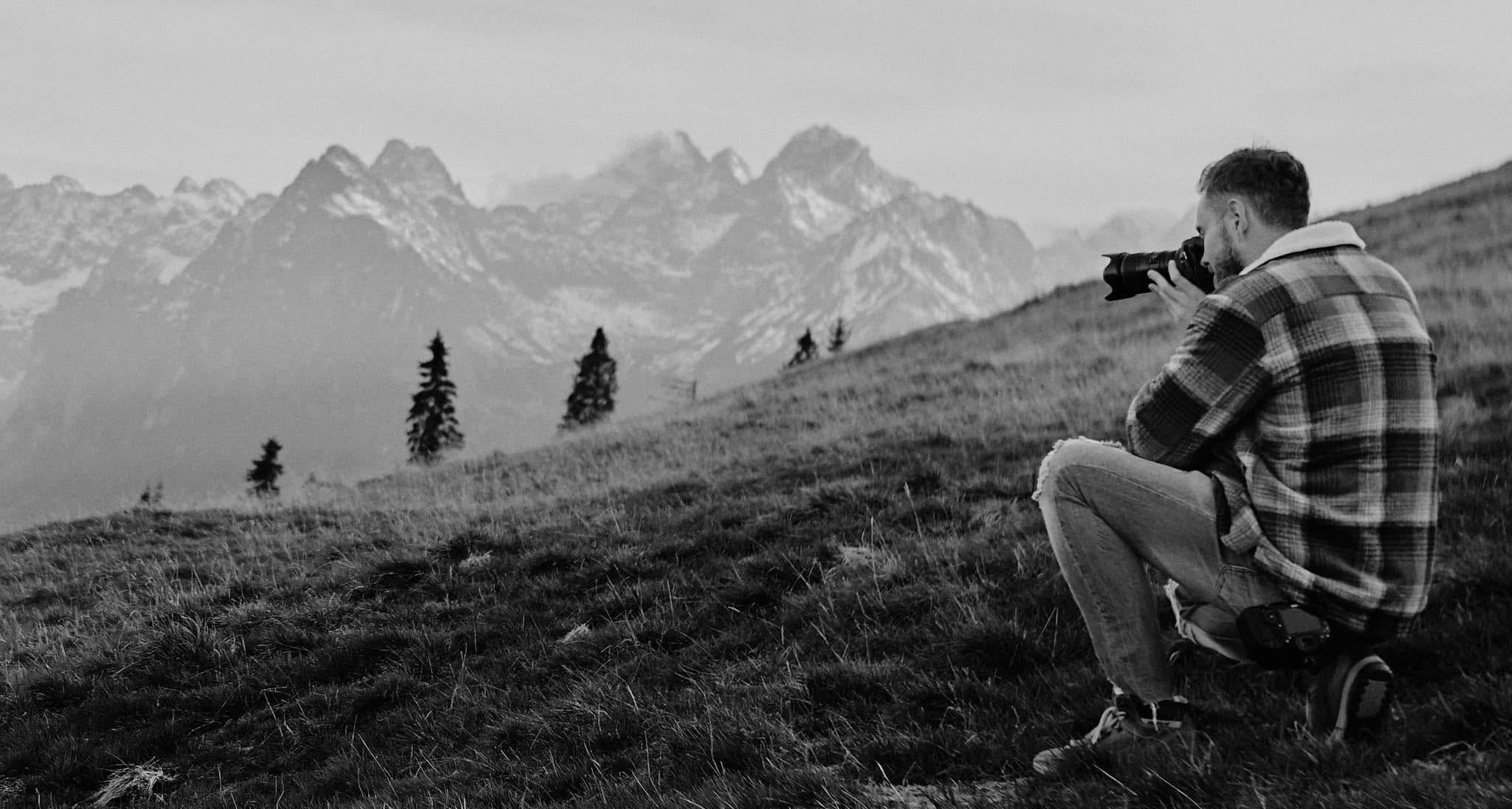 Fotograf z aparatem w górach